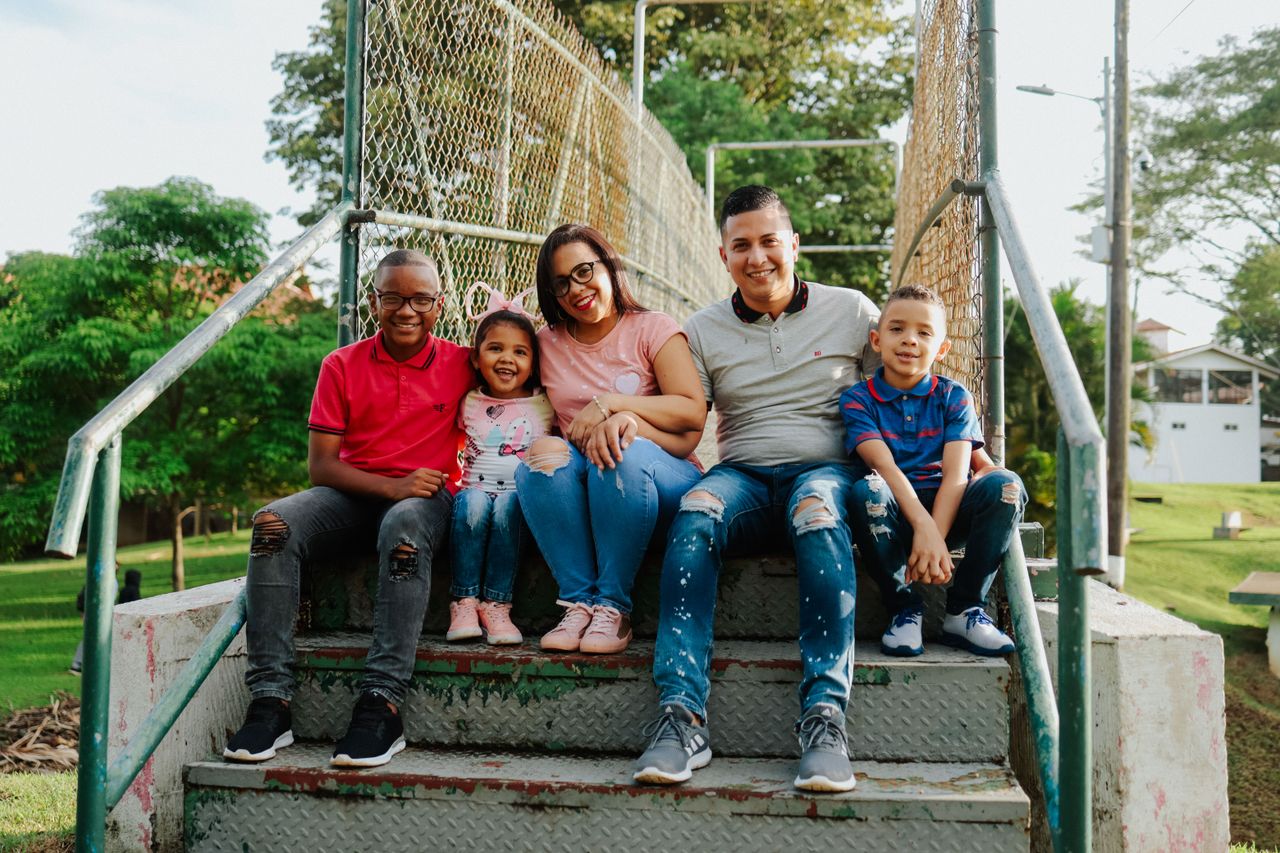 Smiling family enjoying time together on outdoor steps.